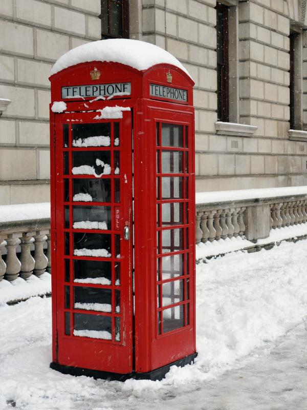 Red phone box in the snow.