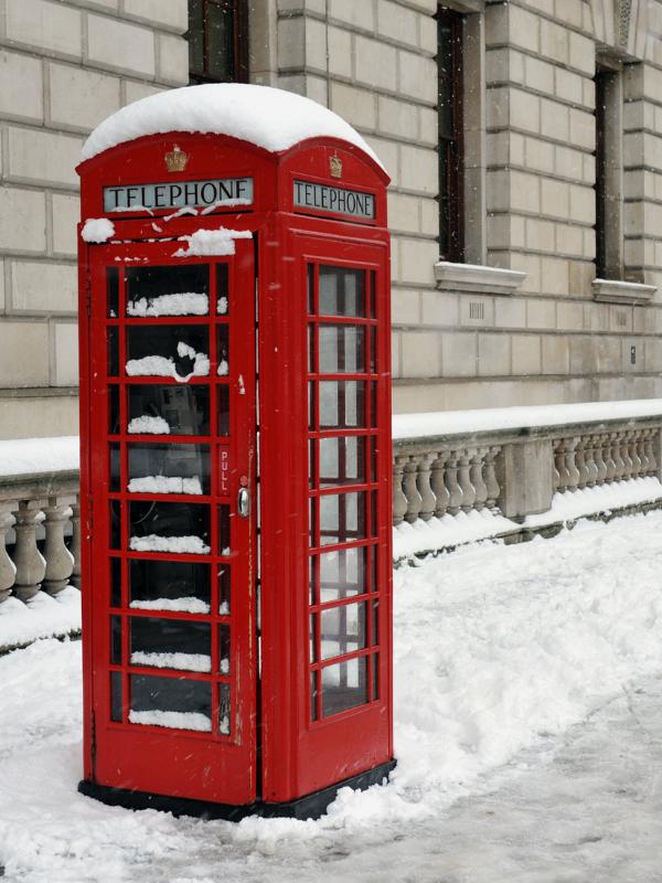 Red phone box in the snow in London.