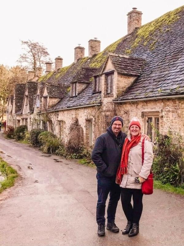 a man and a woman in front of a row of cottages.