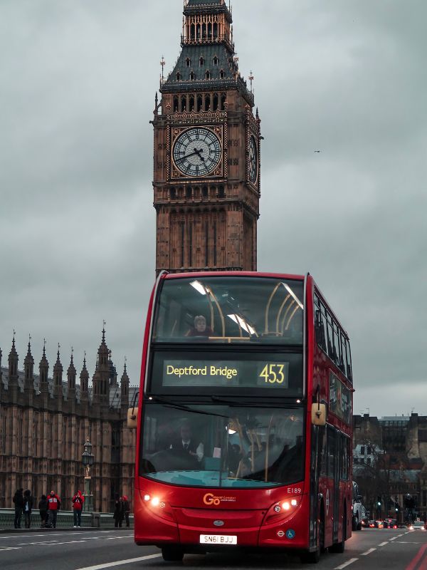 A red London bus in front of Big Ben.