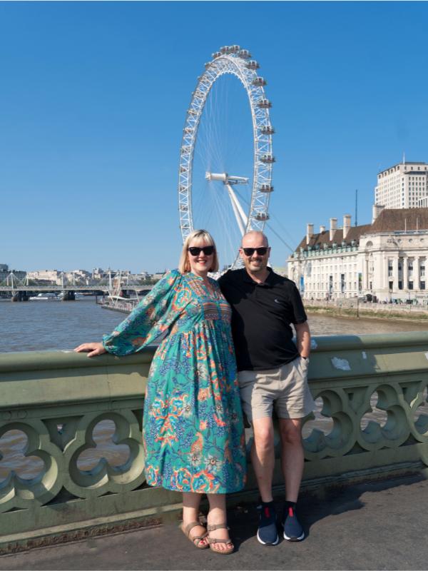 a man and a lady in front of the london eye.