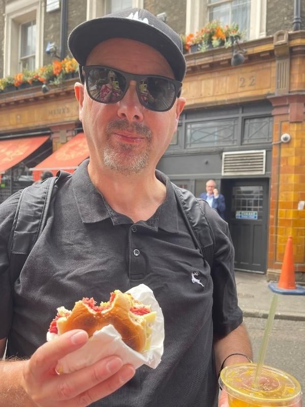 A man holding a sandwich and a drink.