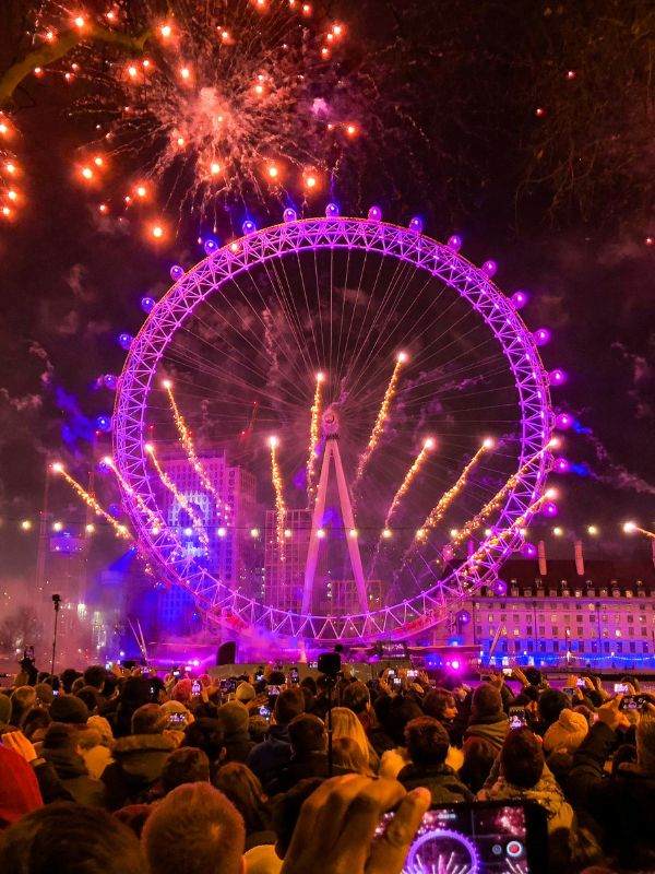 Crowds on Victoria Embankment watching the New Year's Eve fireworks over the London Eye and County Hall.