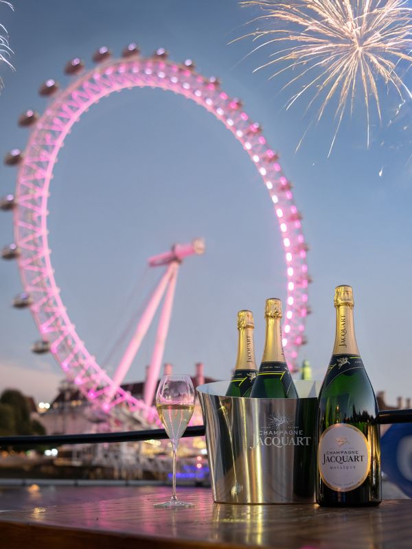Champagne on ice on the deck of a Thames cruise, with the London Eye lit pink and fireworks overhead.