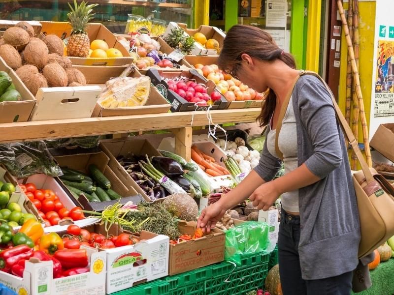 Woman shopping for fruit and vegetables at Brixton market in London.