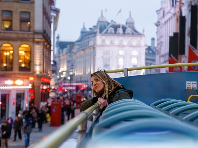 Passenger on the open top deck of a London sightseeing bus