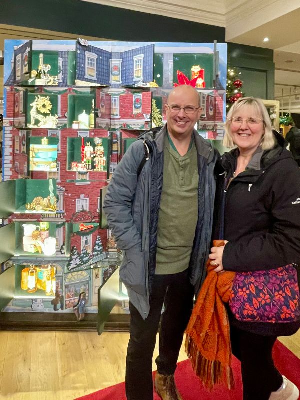 Tracy and Doug in front of the Fortnum and Mason Christmas advent calendar display.