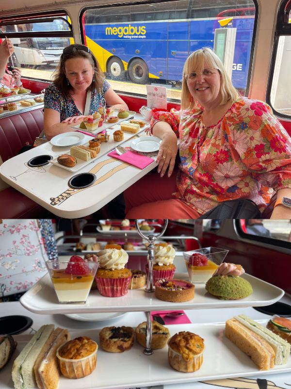 Tracy on board the Brigit’s Bakery afternoon tea bus in London with the tiered stand of cakes and sandwiches