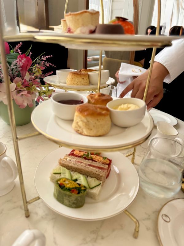 Afternoon tea at The Orangery, Kensington Palace, with scones, sandwiches and pastries on a gold stand
