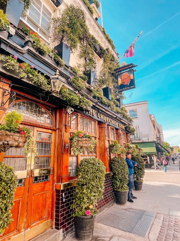 The Churchill Arms pub in Kensington, London, covered in flowers and plants