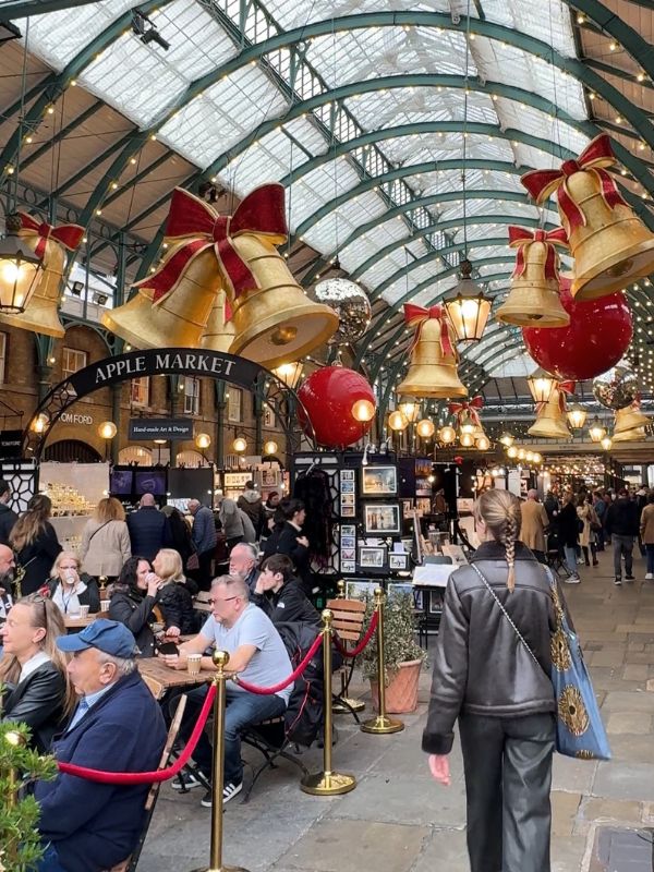 Giant gold bells and red baubles hanging in Covent Garden's Apple Market, already installed in October before the Christmas lights switch-on