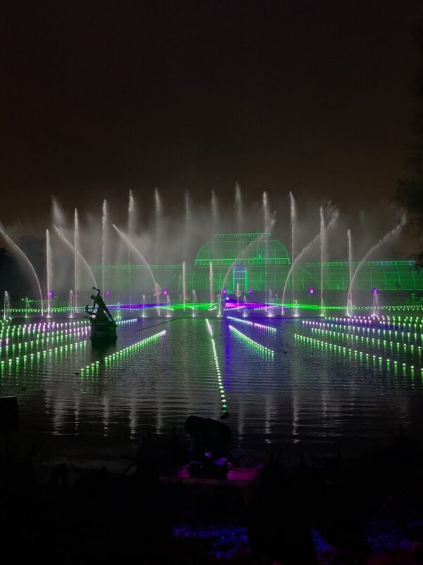The Palm House at Kew Gardens lit green with illuminated fountains on the Christmas at Kew trail