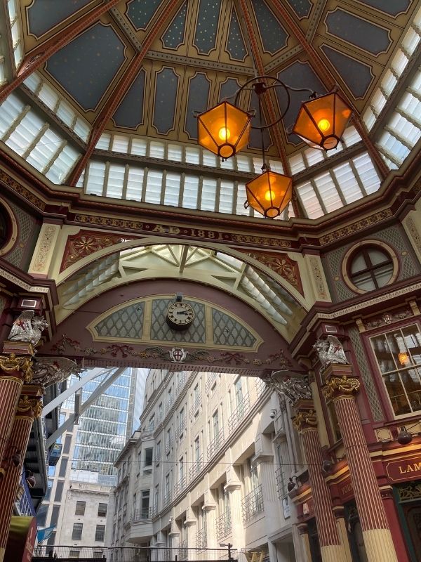 The painted Victorian roof, hanging lanterns and 1881 arch inside Leadenhall Market