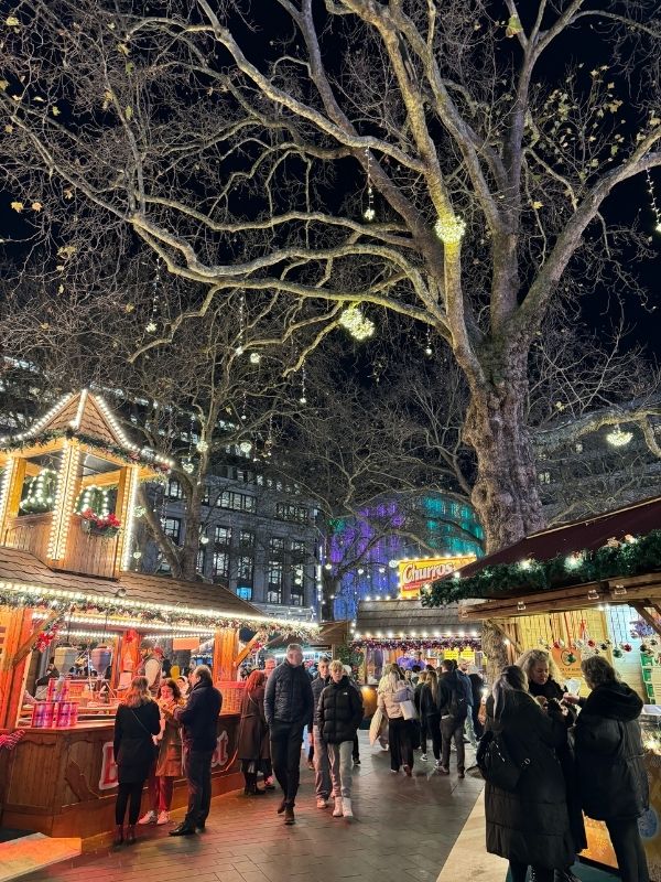 Wooden chalets and lights at the Leicester Square Christmas market at night