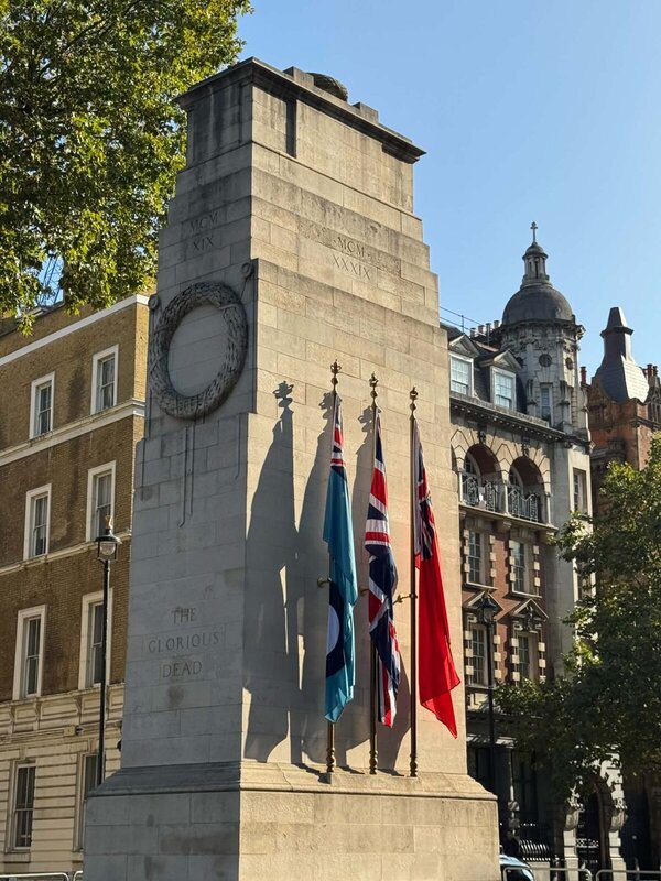 The Cenotaph war memorial on Whitehall in London with Union Flag, RAF and Red Ensign flags and the words The Glorious Dead