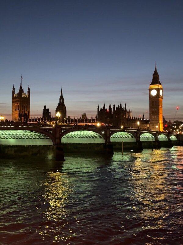 Westminster Bridge lit teal with Big Ben at blue hour on a late November afternoon in London