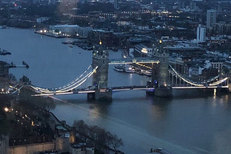 Tower Bridge lit up with lights at night in December.