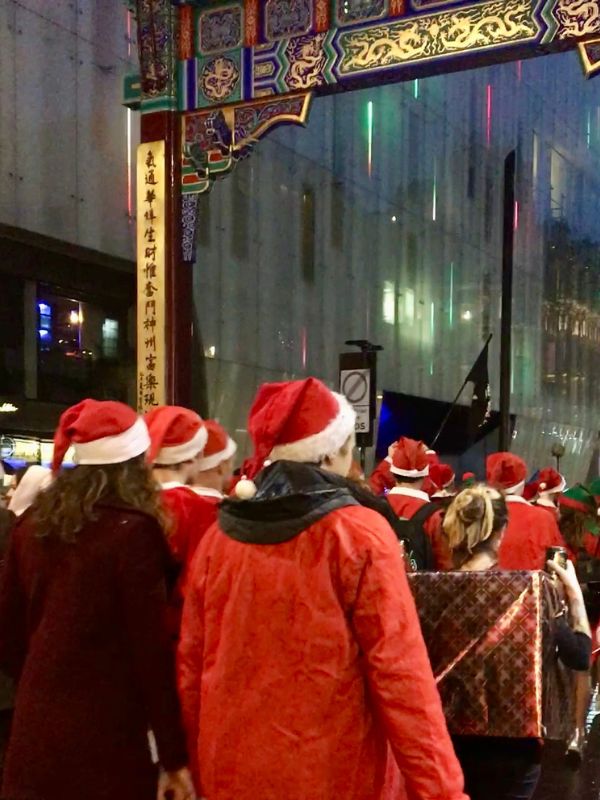 People dressed as Santa walk the streets in London one evening.
