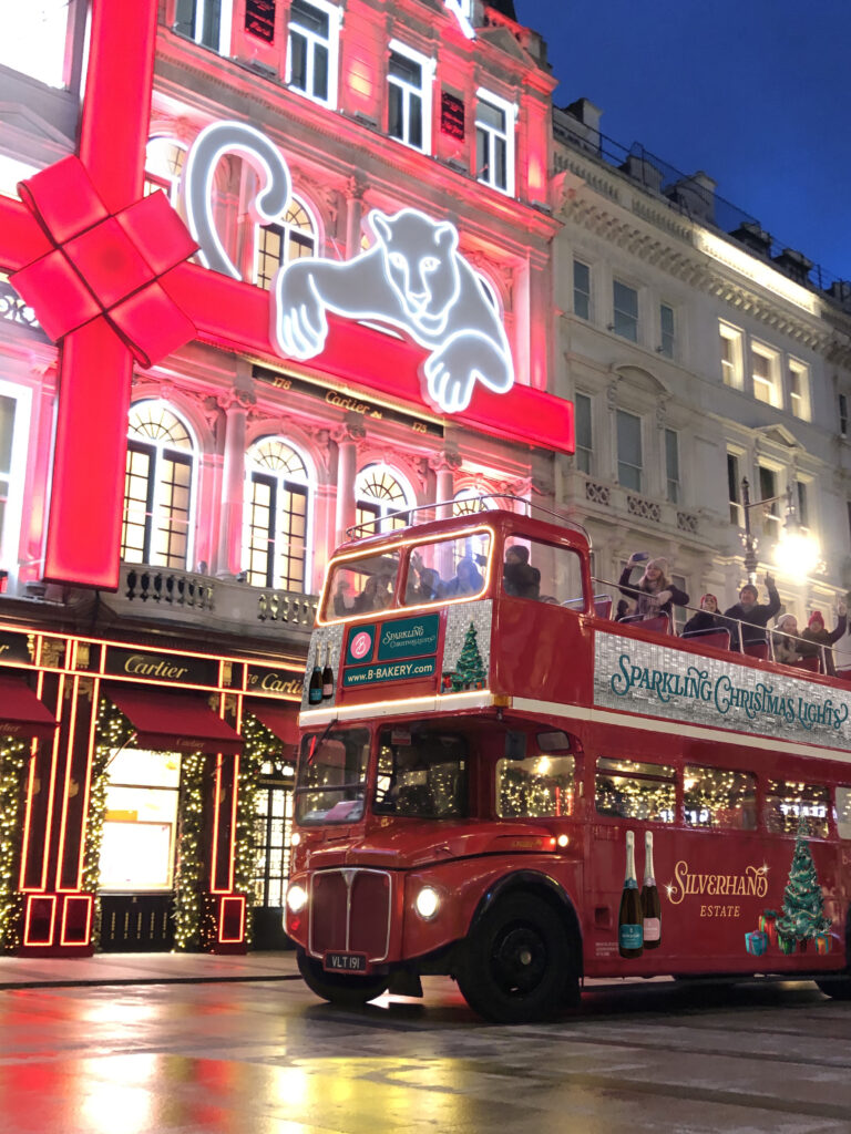 The Brigit’s Bakery Sparkling Christmas Lights Routemaster outside the Cartier store on New Bond Street, wrapped in a giant red Christmas ribbon