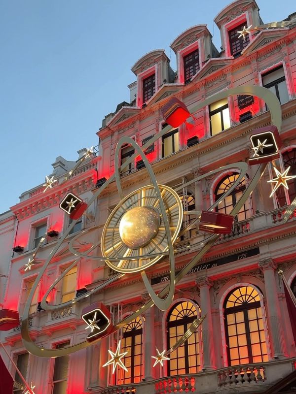 The Cartier shop front on New Bond Street decorated with gold rings, stars and red gift boxes.