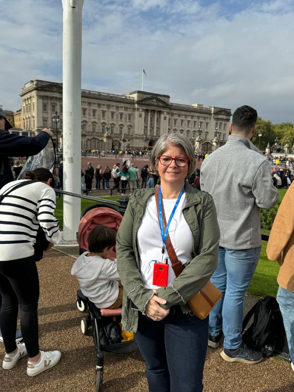 A tour guest wearing a headset receiver in front of Buckingham Palace during the Changing of the Guard
