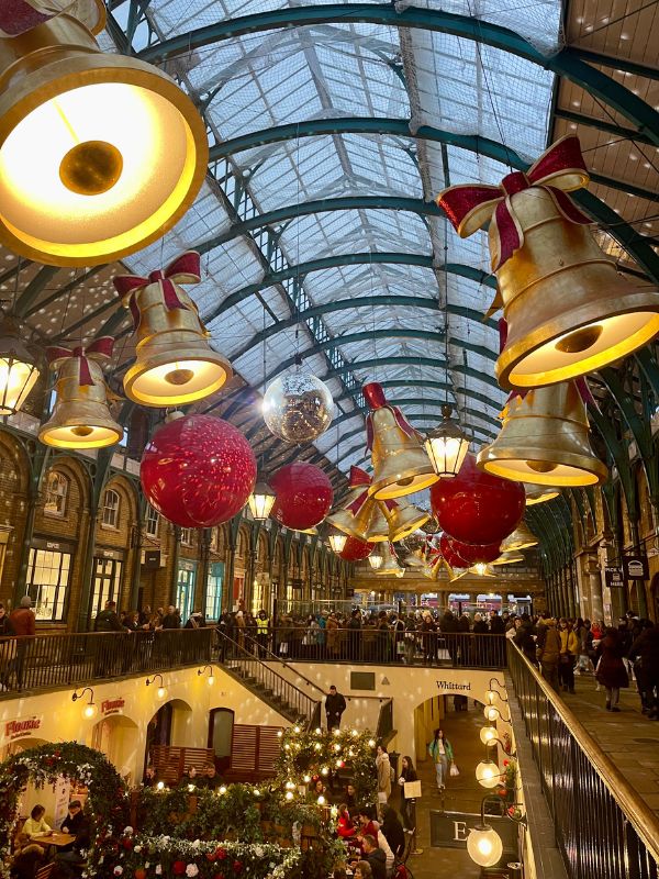 Bells and lanterns hanging from the roof of Covent Garden market at Christmas