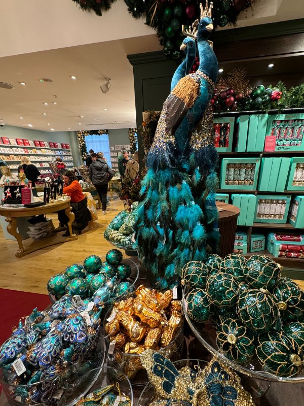 Peacock Christmas decorations and baubles on display inside Fortnum and Mason.