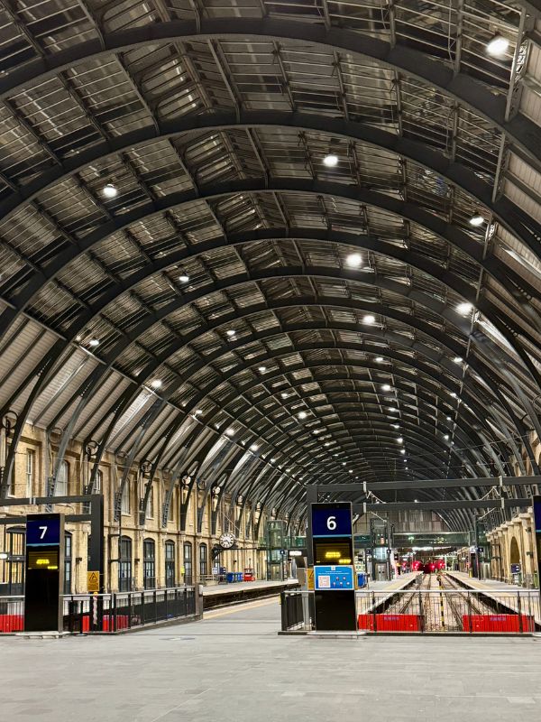 Empty platforms under the arched roof of King's Cross station in winter.