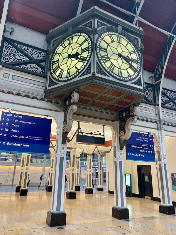 The clock and Elizabeth line signs on an empty concourse at Paddington station.