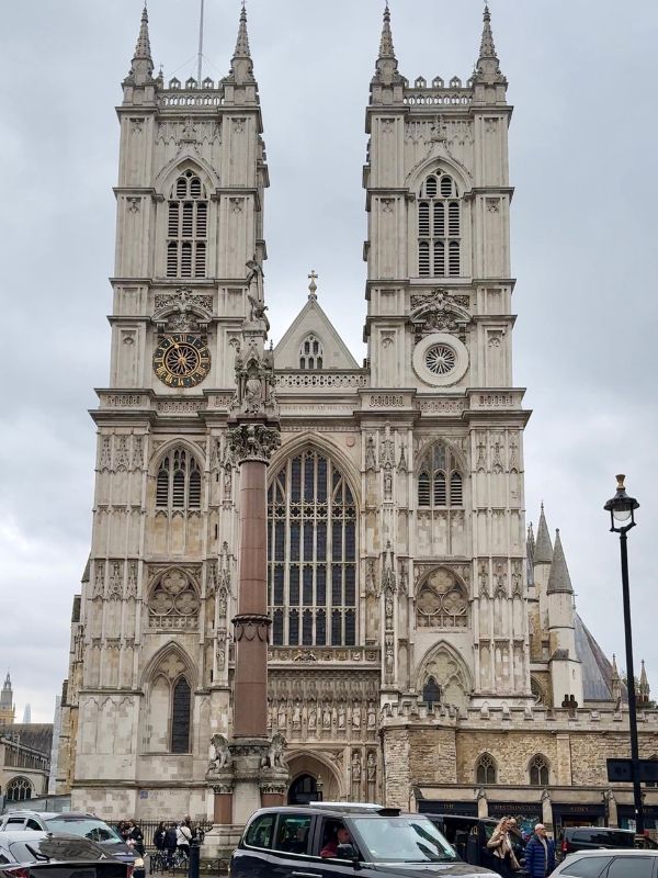 The west front towers of Westminster Abbey with a London black cab passing in front