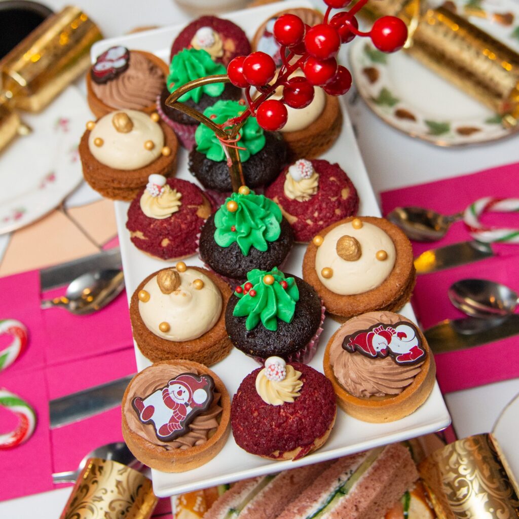 Brigit’s Bakery Christmas afternoon tea cakes, including Christmas tree cupcakes, snowman tarts and red velvet choux buns, served on the Christmas lights bus tour in London
