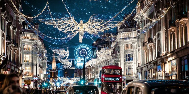 The Christmas angels lit up over Regent Street in London at night, with a red double-decker bus