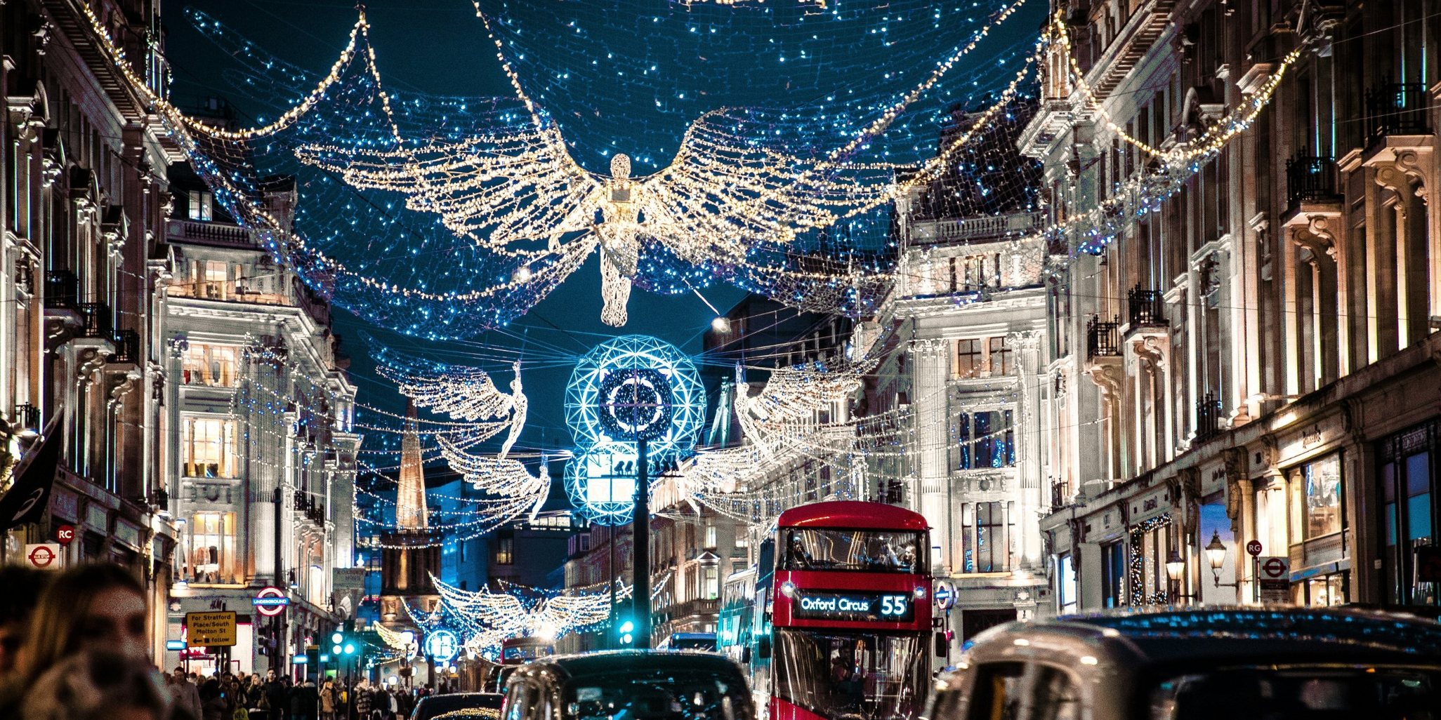 The Christmas angels lit up over Regent Street in London at night, with a red double-decker bus