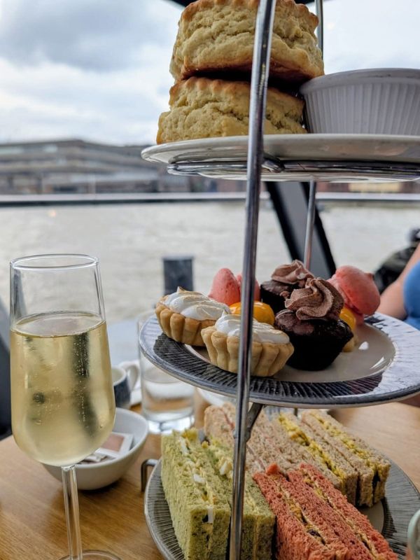 Afternoon tea stand with scones and a glass of fizz on the City Cruises afternoon tea cruise on the Thames
